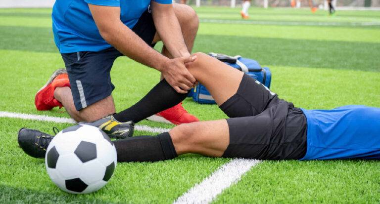 Fisioterapista soccorre un calciatore infortunato al ginocchio: servizio di urgenza per atleti F-Medical Group Frosinone